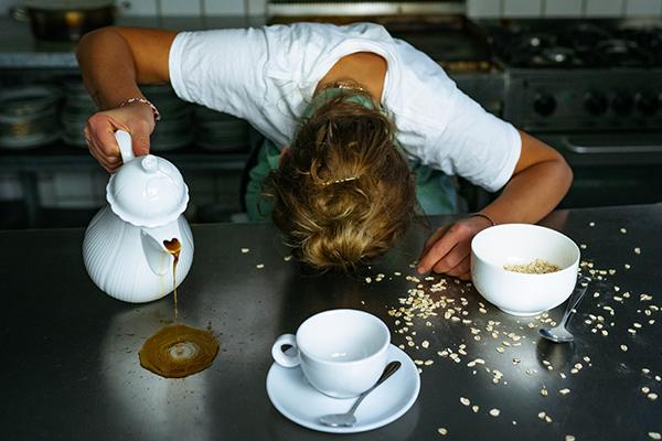Fotografie - Postproduktion, Bildbearbeitung - Agentur. Dieses Bild zeigt eine erschöpfte Frau beim Kaffeeeingießen